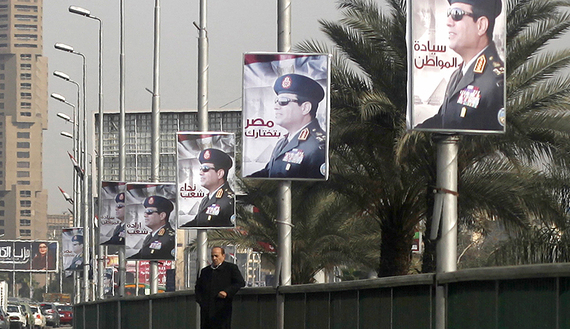 A man stands on a bridge where huge posters of Egypt's army chief Field Marshal Abdel Fattah al-Sisi are hanged in center Cairo